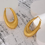 Gold hoop earrings on a textured white surface